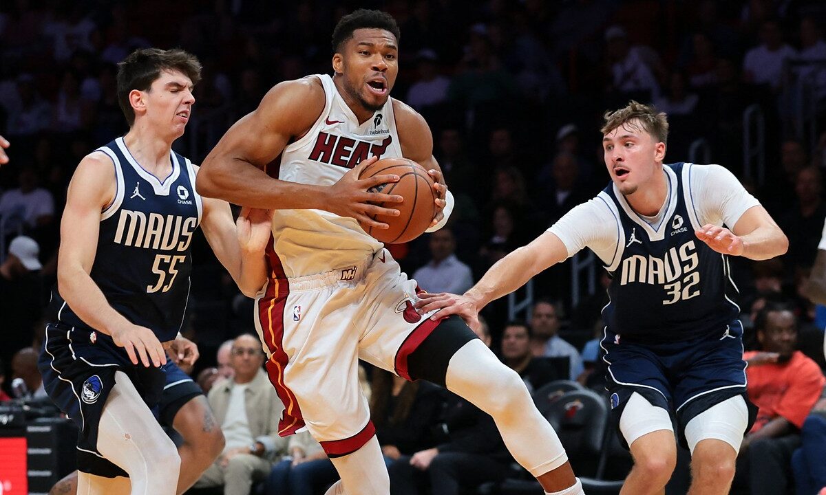 Miami Heat forward Giannis Antetokounmpo drives with the ball between Dallas Mavericks players Sergio de Larrea and Cooper Flagg.