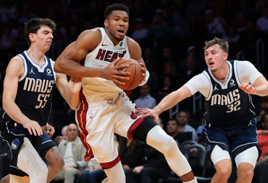 Miami Heat forward Giannis Antetokounmpo drives with the ball between Dallas Mavericks players Sergio de Larrea and Cooper Flagg.