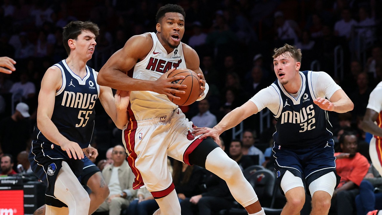 Miami Heat forward Giannis Antetokounmpo drives with the ball between Dallas Mavericks players Sergio de Larrea and Cooper Flagg.