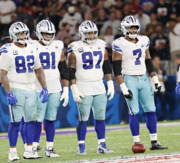 Dallas Cowboys defensive players stand in a row on the field during a game against the Baltimore Ravens in Rio de Janeiro.
