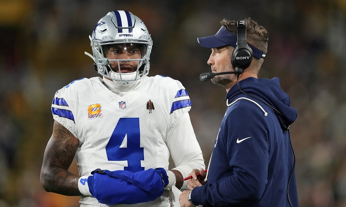 Cowboys quarterback Dak Prescott talks with head coach Brian Schottenheimer on the sideline.