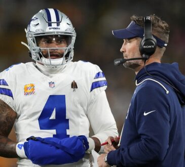 Cowboys quarterback Dak Prescott talks with head coach Brian Schottenheimer on the sideline.