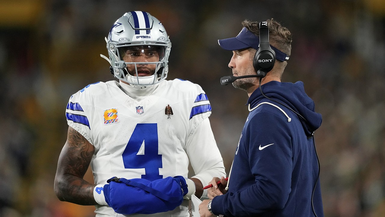 Cowboys quarterback Dak Prescott talks with head coach Brian Schottenheimer on the sideline.