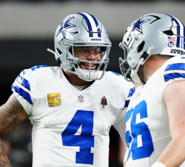 Cowboys quarterback Dak Prescott smiles while talking with center Cooper Beebe during pregame warmups