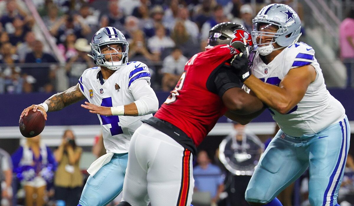 Cowboys quarterback Dak Prescott winds up to throw as a Cowboys lineman blocks a Buccaneers pass rusher.