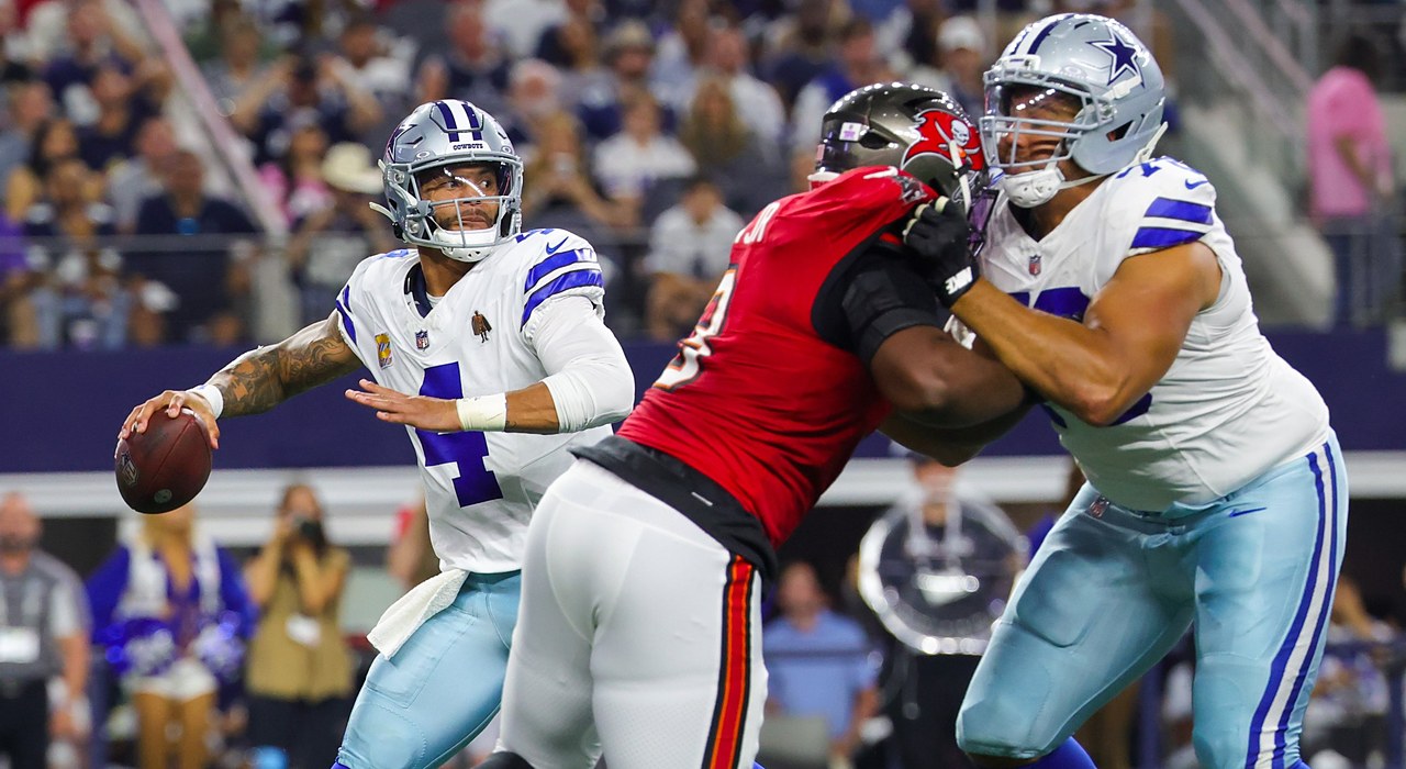Cowboys quarterback Dak Prescott winds up to throw as a Cowboys lineman blocks a Buccaneers pass rusher.