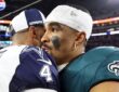 Dallas Cowboys quarterback Dak Prescott embraces Philadelphia Eagles quarterback Jalen Hurts on the field after a game.