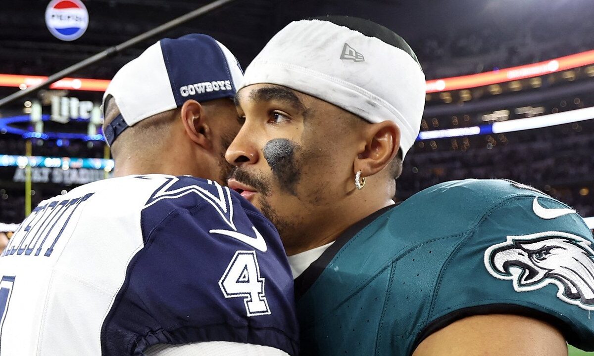 Dallas Cowboys quarterback Dak Prescott embraces Philadelphia Eagles quarterback Jalen Hurts on the field after a game.