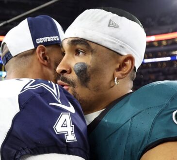 Dallas Cowboys quarterback Dak Prescott embraces Philadelphia Eagles quarterback Jalen Hurts on the field after a game.