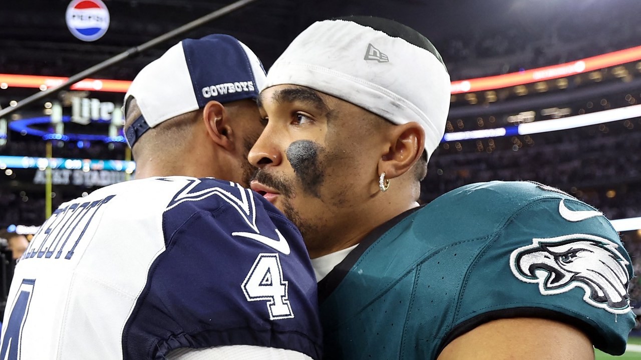Dallas Cowboys quarterback Dak Prescott embraces Philadelphia Eagles quarterback Jalen Hurts on the field after a game.