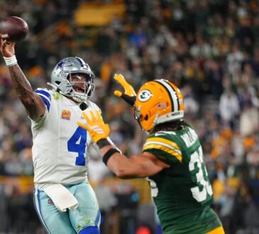 Dallas Cowboys quarterback Dak Prescott throws a pass on the run as Green Bay Packers safety Evan Williams closes in.