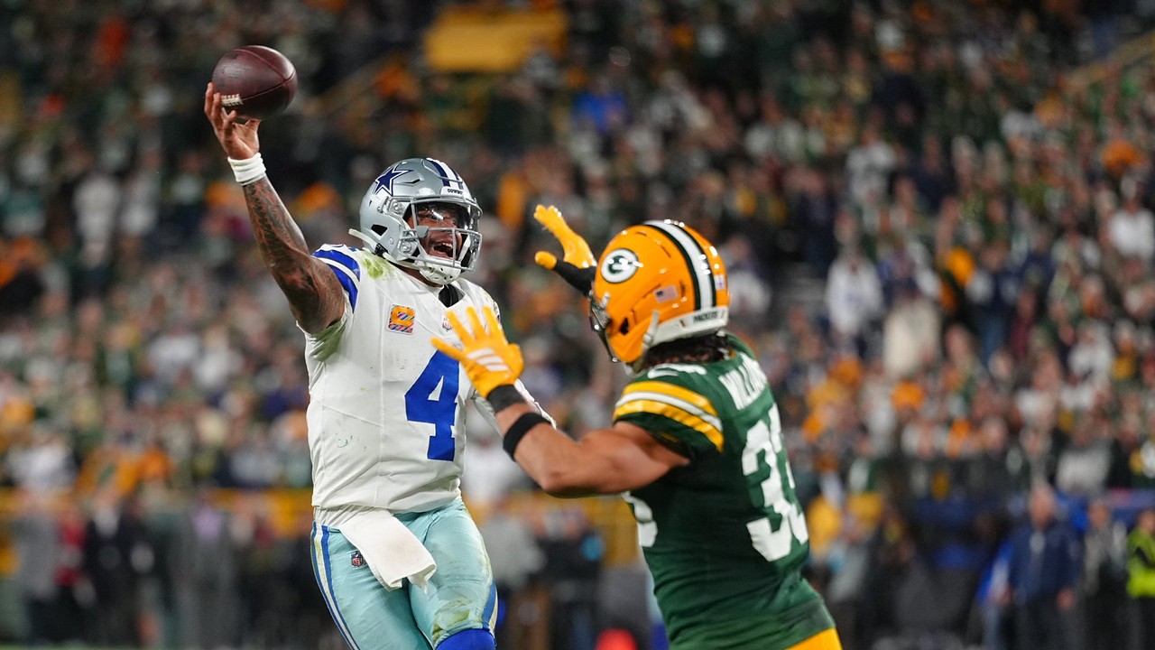 Dallas Cowboys quarterback Dak Prescott throws a pass on the run as Green Bay Packers safety Evan Williams closes in.