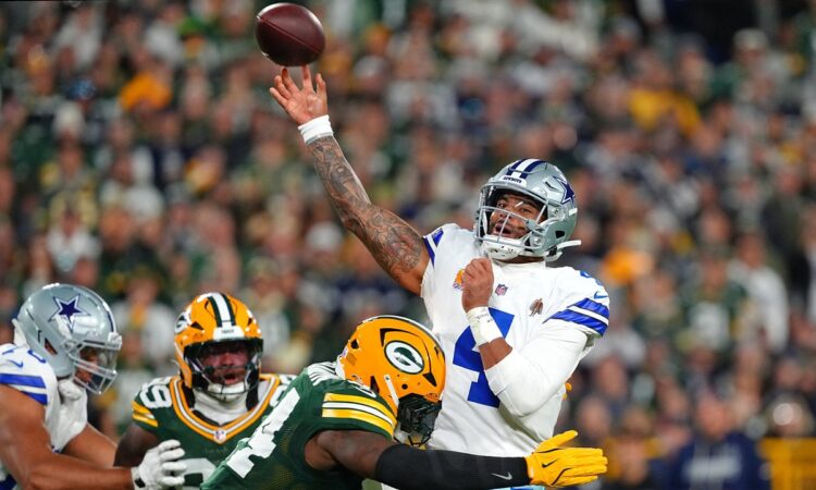 Dallas Cowboys quarterback Dak Prescott releases a pass as Green Bay Packers linebacker Zaire Franklin hits him.