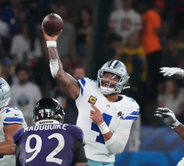 Dallas Cowboys quarterback Dak Prescott throws a pass from the pocket as a Baltimore Ravens defender rushes.