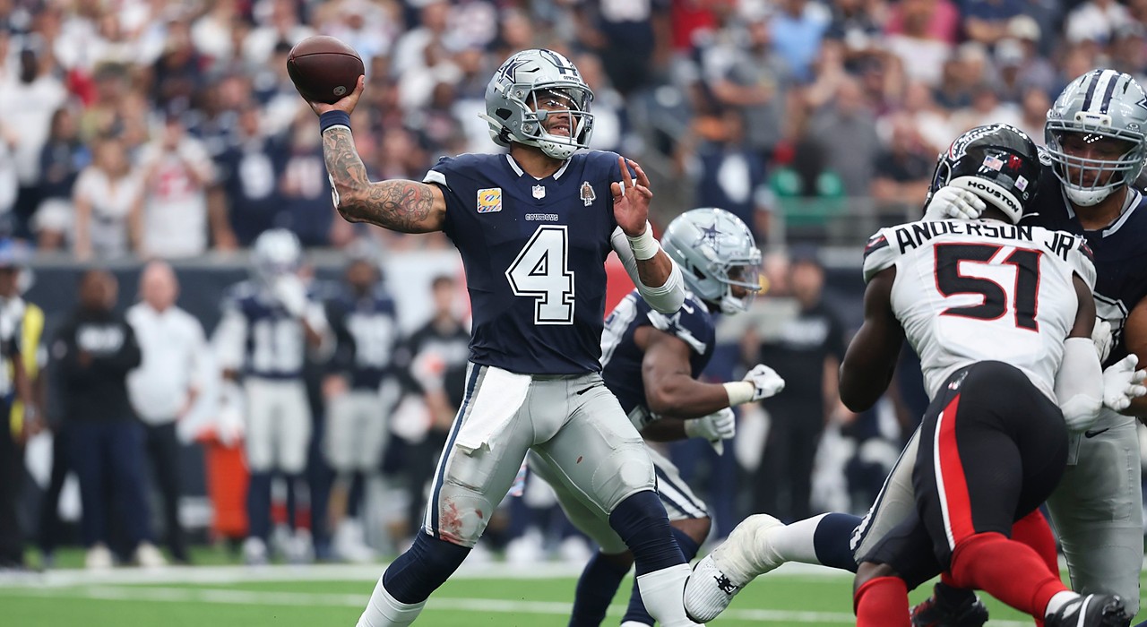 Cowboys quarterback Dak Prescott winds up to throw as Texans No. 51 rushes in from the right.
