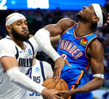 Dallas Mavericks forward Daniel Gafford swipes at the ball as Oklahoma City Thunder guard Shai Gilgeous-Alexander grimaces on contact.