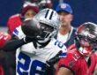 Cowboys cornerback DaRon Bland reaches for the ball with one hand as Buccaneers receiver Emeka Egbuka watches.
