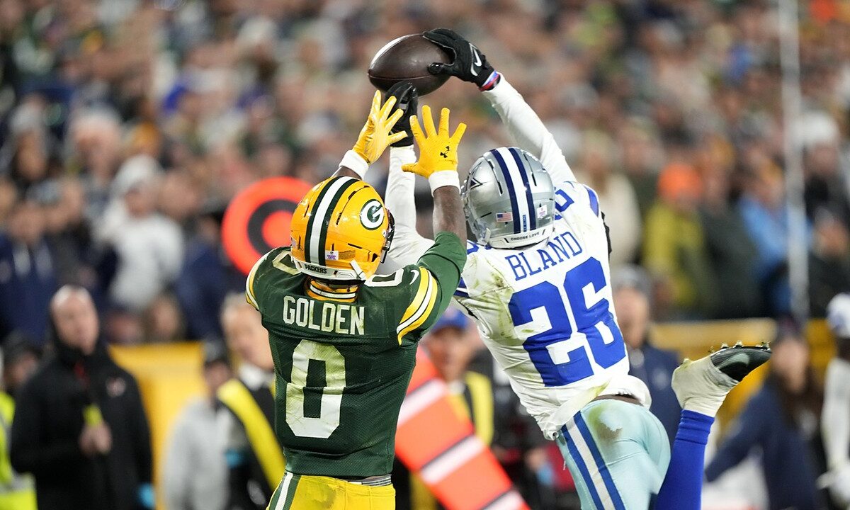 Dallas Cowboys cornerback DaRon Bland leaps to knock away a pass over Green Bay Packers wide receiver Matthew Golden.