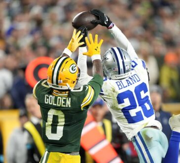 Dallas Cowboys cornerback DaRon Bland leaps to knock away a pass over Green Bay Packers wide receiver Matthew Golden.