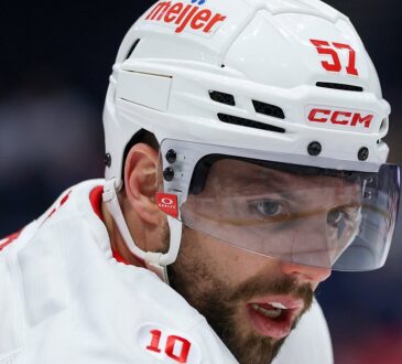 Then-Detroit Red Wings left wing David Perron, in a white helmet and visor, looks across the ice during warmups.
