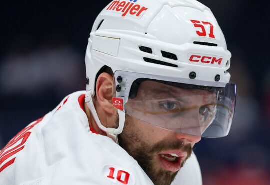 Then-Detroit Red Wings left wing David Perron, in a white helmet and visor, looks across the ice during warmups.