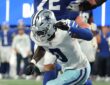 Dallas Cowboys linebacker DeMarvion Overshown lunges toward the goal line during a play.