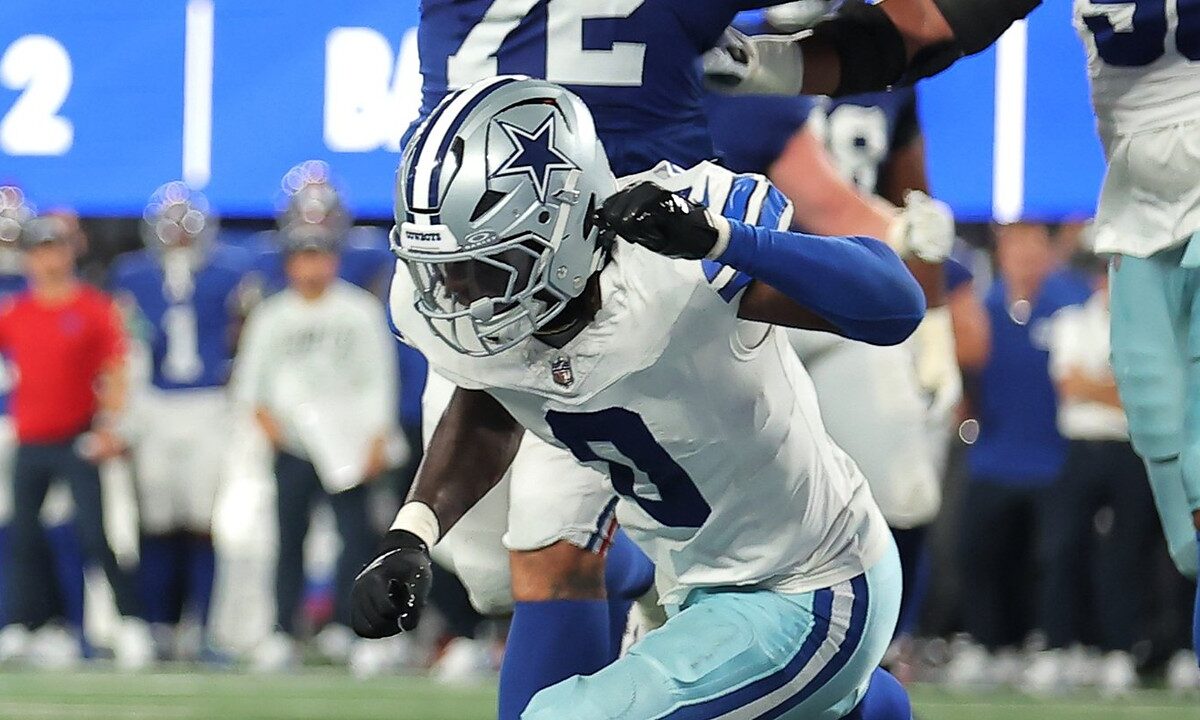 Dallas Cowboys linebacker DeMarvion Overshown lunges toward the goal line during a play.