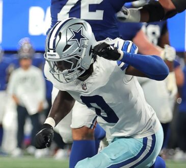 Dallas Cowboys linebacker DeMarvion Overshown lunges toward the goal line during a play.