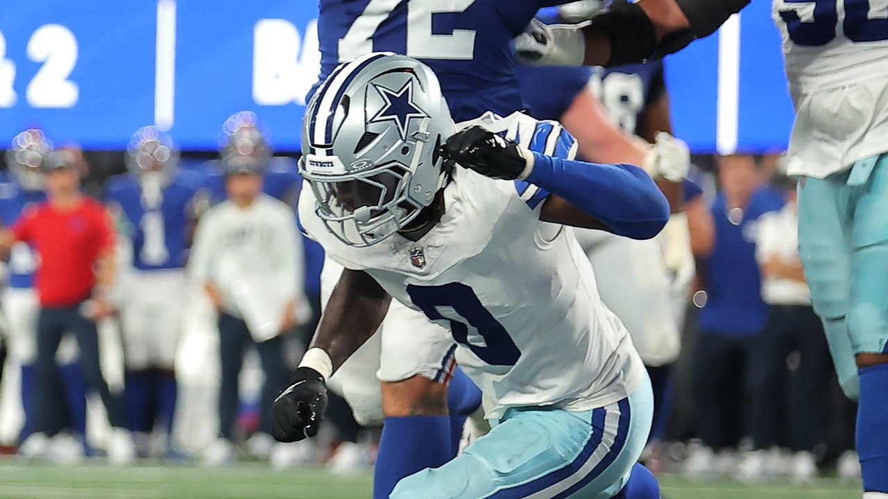Dallas Cowboys linebacker DeMarvion Overshown lunges toward the goal line during a play.