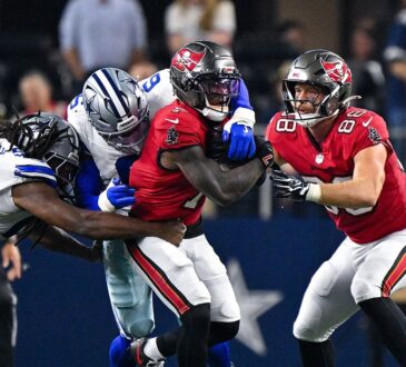 Cowboys linebacker Donovan Ezeiruaku and teammates wrap up Buccaneers running back Bucky Irving on a run.