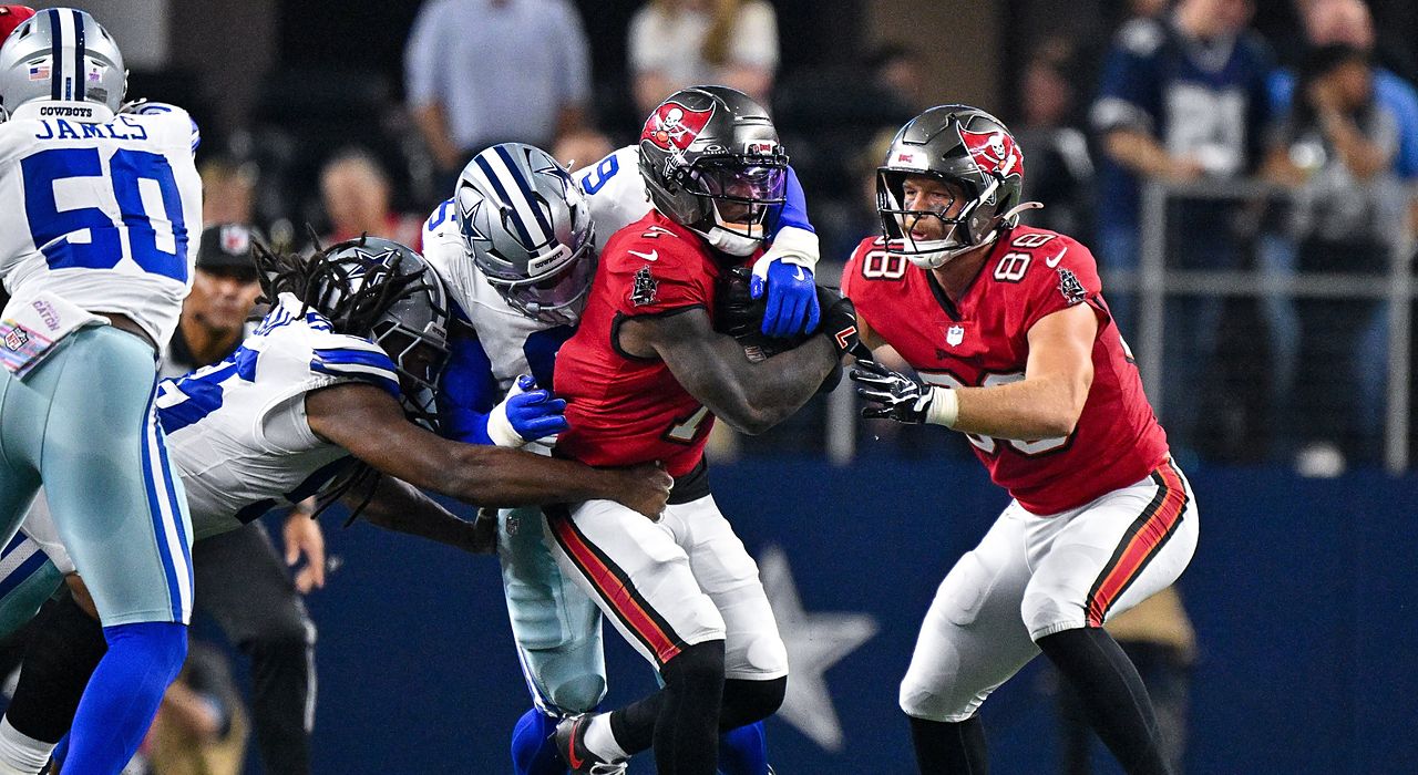 Cowboys linebacker Donovan Ezeiruaku and teammates wrap up Buccaneers running back Bucky Irving on a run.