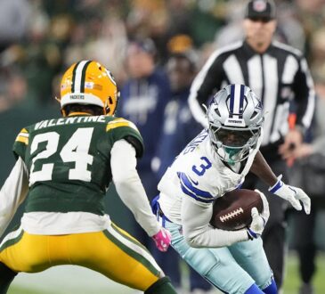 Dallas Cowboys wide receiver George Pickens cuts upfield with the ball as Green Bay Packers cornerback Carrington Valentine squares up.