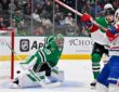 Dallas Stars goaltender Jake Oettinger drops into a split as the puck slides past his pad toward the net.