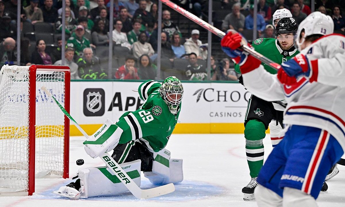 Dallas Stars goaltender Jake Oettinger drops into a split as the puck slides past his pad toward the net.