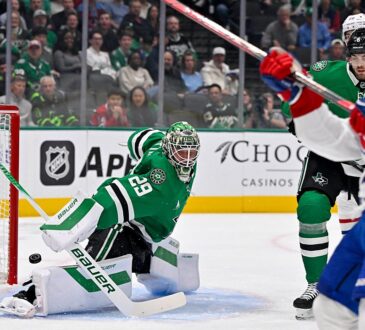 Dallas Stars goaltender Jake Oettinger drops into a split as the puck slides past his pad toward the net.
