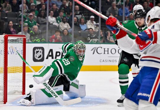Dallas Stars goaltender Jake Oettinger drops into a split as the puck slides past his pad toward the net.