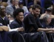 Oklahoma City Thunder players Jalen Williams, Jared McCain, and Chet Holmgren smile while watching from the bench in street clothes.