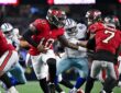 Buccaneers quarterback Jalon Daniels hands the ball to running back Bucky Irving as linemen battle behind them.
