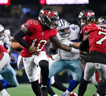 Buccaneers quarterback Jalon Daniels hands the ball to running back Bucky Irving as linemen battle behind them.