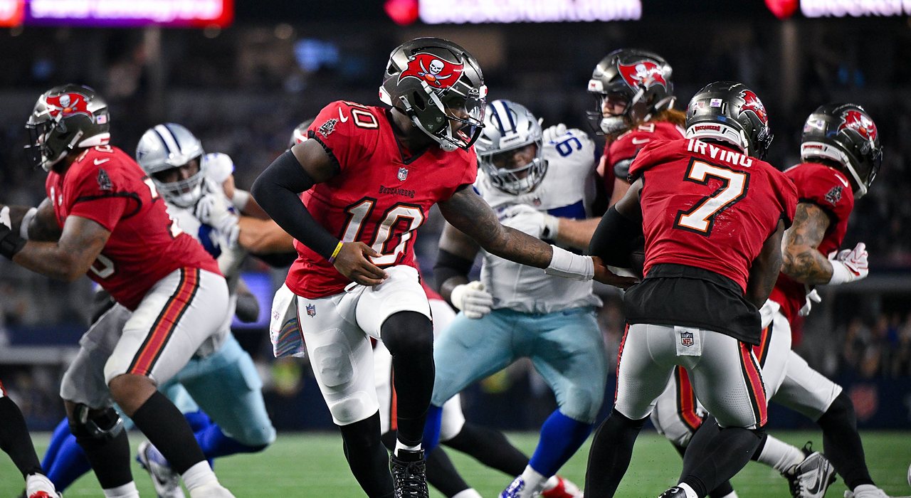 Buccaneers quarterback Jalon Daniels hands the ball to running back Bucky Irving as linemen battle behind them.