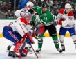 Stars left wing Jamie Benn battles Canadiens defenseman Lane Hutson in front of goaltender Jakub Dobeš.