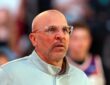 Then-Mavericks head coach Jason Kidd, wearing clear-framed glasses, looks on from the sideline with fans behind him.