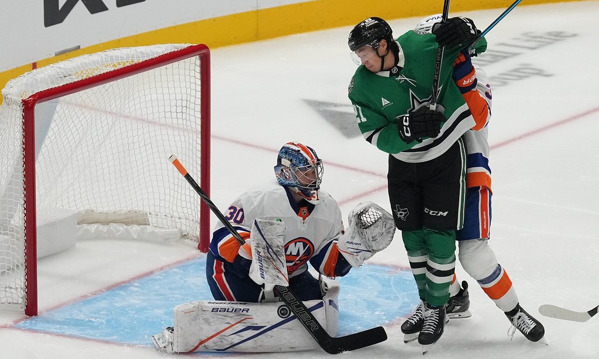 Dallas Stars left wing Jason Robertson battles in front as New York Islanders goaltender Ilya Sorokin blocks the puck with his pad.