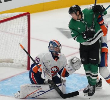 Dallas Stars left wing Jason Robertson battles in front as New York Islanders goaltender Ilya Sorokin blocks the puck with his pad.