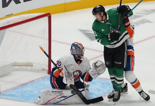 Dallas Stars left wing Jason Robertson battles in front as New York Islanders goaltender Ilya Sorokin blocks the puck with his pad.