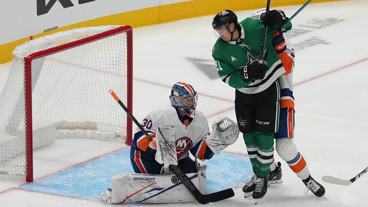 Dallas Stars left wing Jason Robertson battles in front as New York Islanders goaltender Ilya Sorokin blocks the puck with his pad.