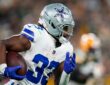 Dallas Cowboys running back Javonte Williams runs with the ball tucked under his right arm.