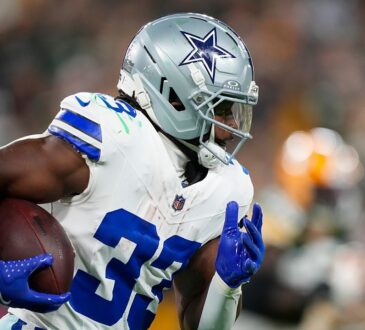 Dallas Cowboys running back Javonte Williams runs with the ball tucked under his right arm.