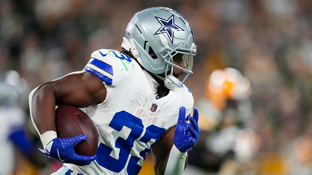 Dallas Cowboys running back Javonte Williams runs with the ball tucked under his right arm.