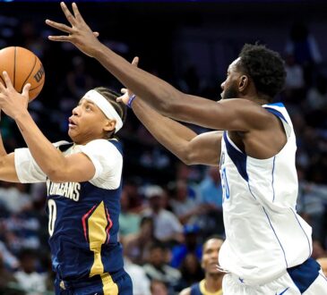 Pelicans guard Jeremiah Fears snatches the ball in midair as Mavericks center Moussa Cisse reaches in from behind.